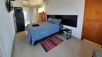 A bedroom with a bed, bedside table, and a door.