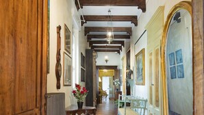 A hallway with wooden beams, a radiator, a bench, and a mirror. - Corte Rosantico (Bussolengo)