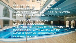 Zona de piscina con un texto superpuesto que ofrece información sobre un servicio especial para nadadores, incluyendo un cargo y la obligatoriedad de usar gorro de baño.