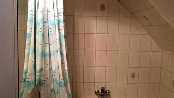 A bathroom with a bathtub, a sink, and a shower curtain with a bird pattern.