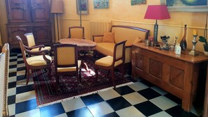 A room with a checkered floor, wooden furniture, a radiator, and wall art. - Domaine de la Coudraye (La Haye-du-Theil)