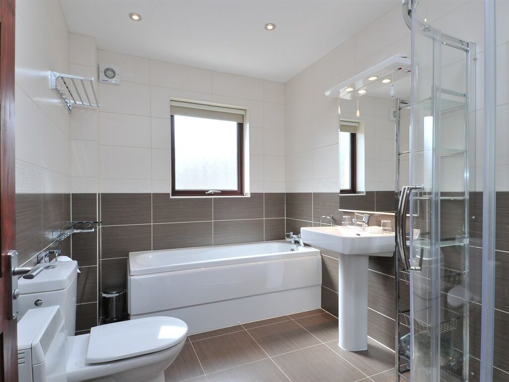 A modern bathroom with a bathtub, toilet, and sink.