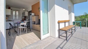 A modern apartment with a kitchen, dining area, and a balcony with a bench. - Logicasa Zazzi House (Como)