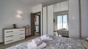 A bedroom with a bed, a dresser, a mirror, and a wardrobe. - Logicasa Zazzi House (Como)