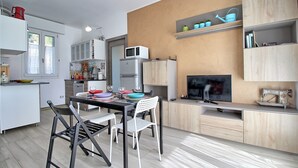 A modern kitchen with a dining area, a TV, and a sewing machine. - Logicasa Zazzi House (Como)