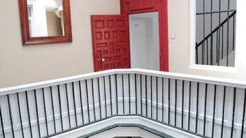 Eine Treppe mit einer weißen Geländer und einer roten Tür im Hintergrund.