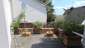 A wooden deck with planters and seating. - Hotel Molitor (Bad Homburg v.d. Hoehe)