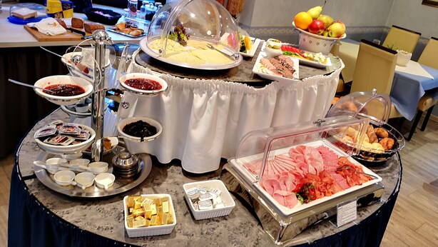 A buffet with various food items and condiments. - Hotel Molitor (Bad Homburg v.d. Hoehe)