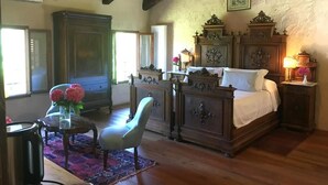 Een klassieke slaapkamer met een houten bed, een grote garderobe en een stoel.