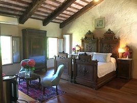 Un dormitorio tradicional con una cama de madera, un armario grande y una silla.