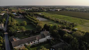 A rural landscape with a large white building surrounded by fields and trees.