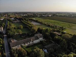 A rural landscape with a large white building surrounded by fields and trees. - B&B Cà Cinel Asolo (Asolo)