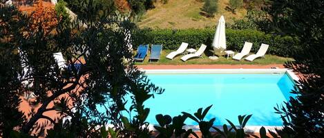 Een buitenzwembad en ligstoelen