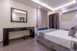Un dormitorio moderno con cama, mesita de noche y espejo.