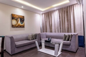 Un saló modern amb un sofà modular, una taula de centre de vidre i un quadre a la paret.