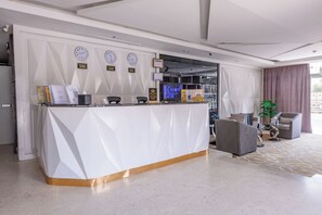 Un comptoir d’accueil avec des horloges, un écran d’ordinateur et un espace détente.