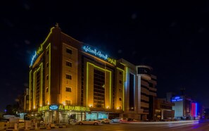 Ein Hotel mit auffälligem arabischem Schriftzug, mehreren Etagen und modernem architektonischem Design.