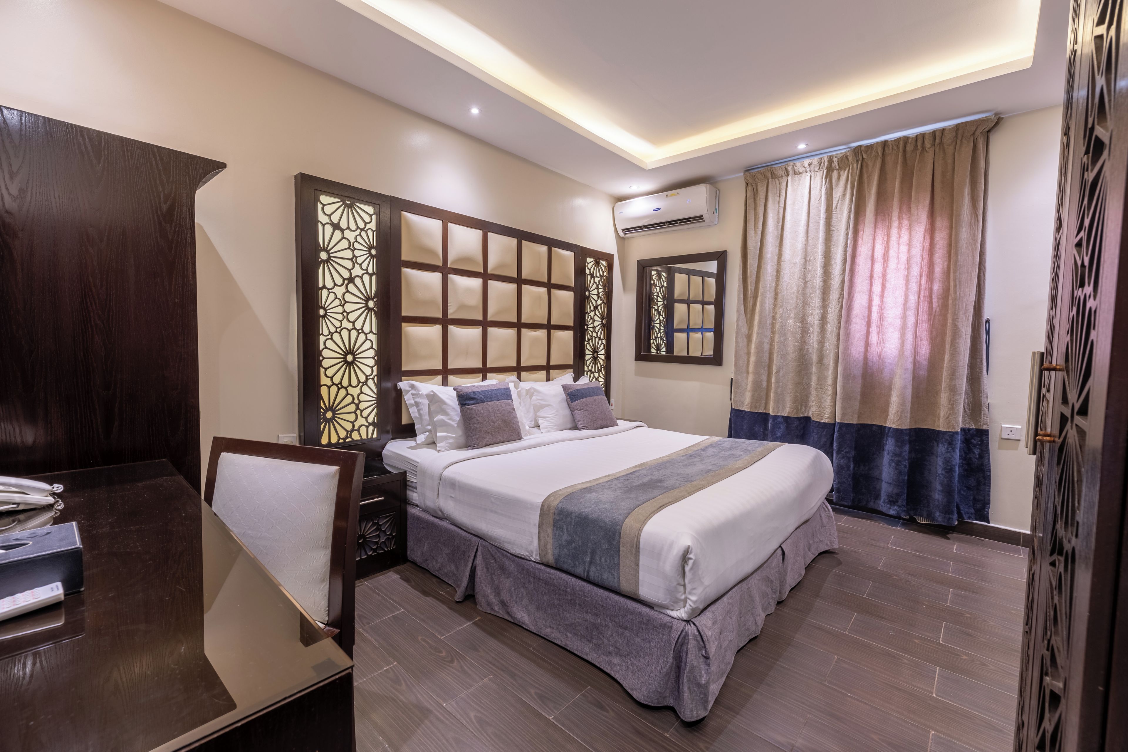 Une chambre d’hôtel moderne avec un grand lit, un bureau et une armoire.