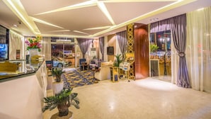 Un moderno vestíbulo de hotel con mostrador de recepción, zona de estar y un diseño decorativo en el suelo.