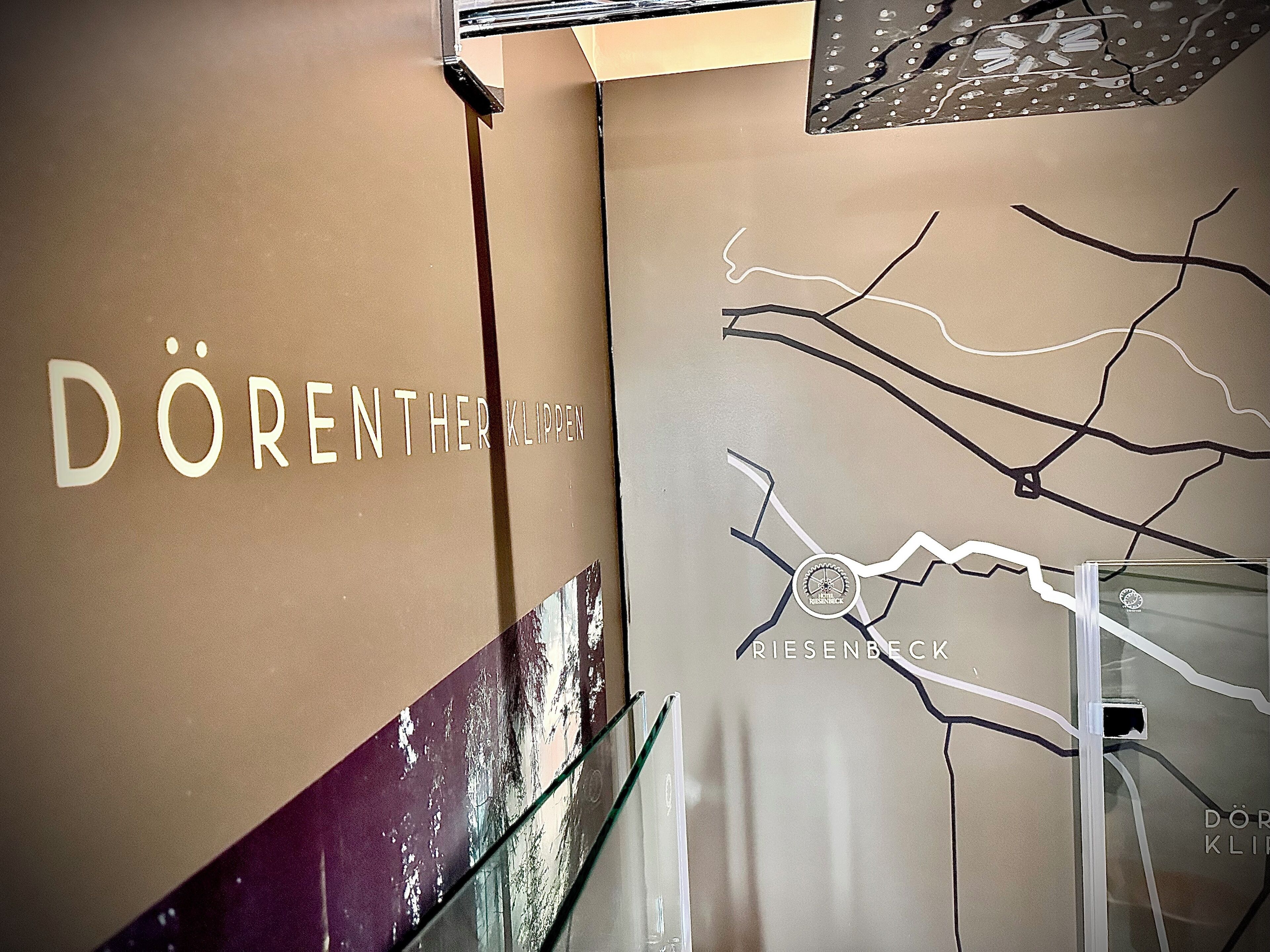 Un mur sur lequel est inscrit le texte « DÖRENTHER KLIPPEN » et qui présente un motif représentant une carte routière.