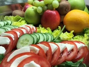 A salad with tomatoes, cucumbers, lettuce, and cheese.