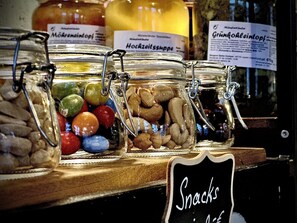 Un mostrador con frascos que contienen nueces y caramelos de colores.