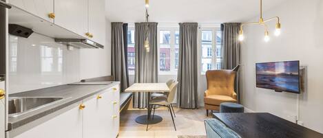 Una cocina moderna con comedor, sofá y televisor.