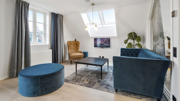 A modern living room with a sofa, ottoman, armchair, and a coffee table. - VANDER - Sea Story (Stavanger)