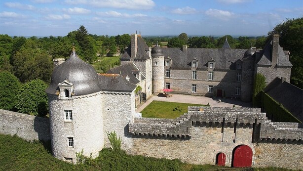 Un château de pierre historique, doté de plusieurs tours, d’une cour intérieure et d’un mur d’enceinte.
