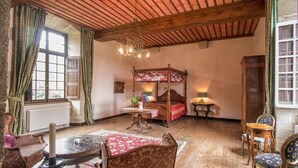 Une chambre à coucher de style traditionnel, avec un lit à baldaquin, un lustre et des meubles classiques.
