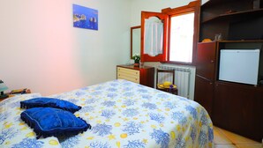 A bedroom with a bed, a dresser, a mirror, a radiator, and a wardrobe. - B&B La Maison De Titty & Margy (Piano di Sorrento)