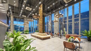 Un hall d’entrée spacieux, doté d’un haut plafond, de grandes fenêtres et de mobilier moderne.