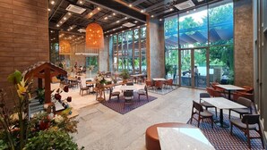 Un espace intérieur vaste et lumineux, doté de nombreux coins salon, de grandes fenêtres et d’un design moderne au niveau du plafond.