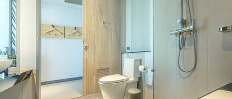 Un baño moderno con inodoro, ducha y lavamanos.