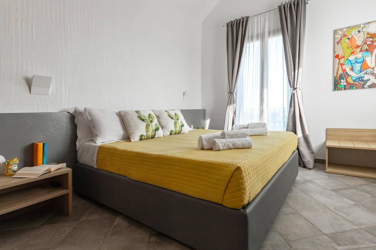 A neatly arranged bedroom with a bed, bedside table, and a bench.
