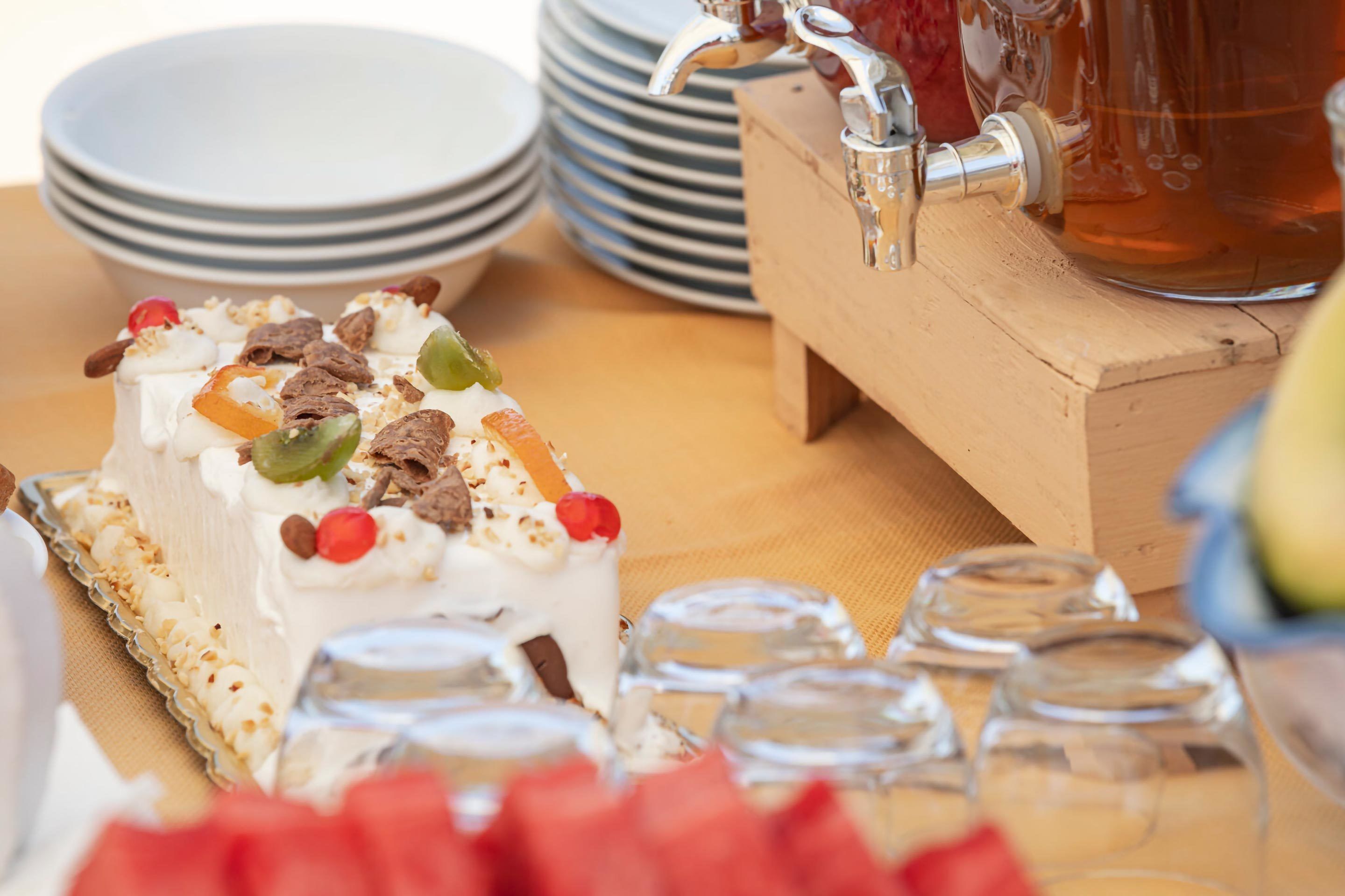 A dessert with various toppings, a beverage tap, and stacked plates.