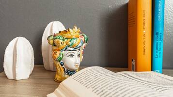 A ceramic head sculpture, a book, and two books on a shelf.