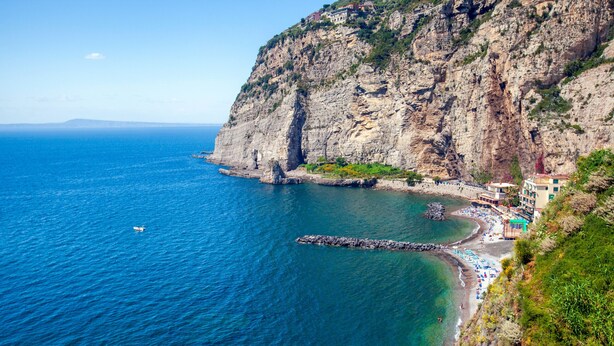 Hotel a la costa amb vistes a un penya-segat, una platja i una roca.
