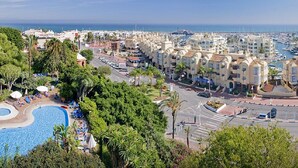 Un hôtel situé sur la côte, doté d’une piscine, d’un port de plaisance et offrant une vue sur la mer.