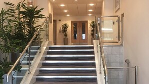 A modern staircase with metal railings, leading to a door at the top. - Modern Apartment By Creatick (Reading)