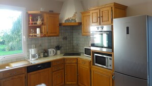 A kitchen with wooden cabinets, a stainless steel refrigerator, a microwave, and a dishwasher. - Gite in France, 3 stars, 11 prs, comfortable, relaxing, in natural environment (Vacqueriette-Erquières)