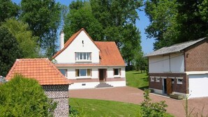A two-story house with a red-tiled roof, a brick chimney, and a small garden area. - Gite in France, 3 stars, 11 prs, comfortable, relaxing, in natural environment (Vacqueriette-Erquières)