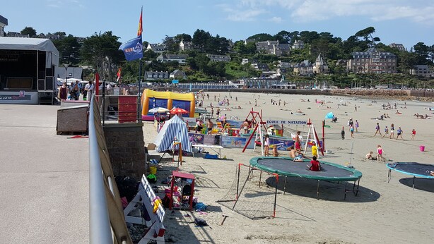 A beach with inflatable play areas, a stage, and a sign for 'Ecole de Natation'. - Gîtes Les COSTANS & A Proximité plages 800M & Commerces 300M (Perros-Guirec)