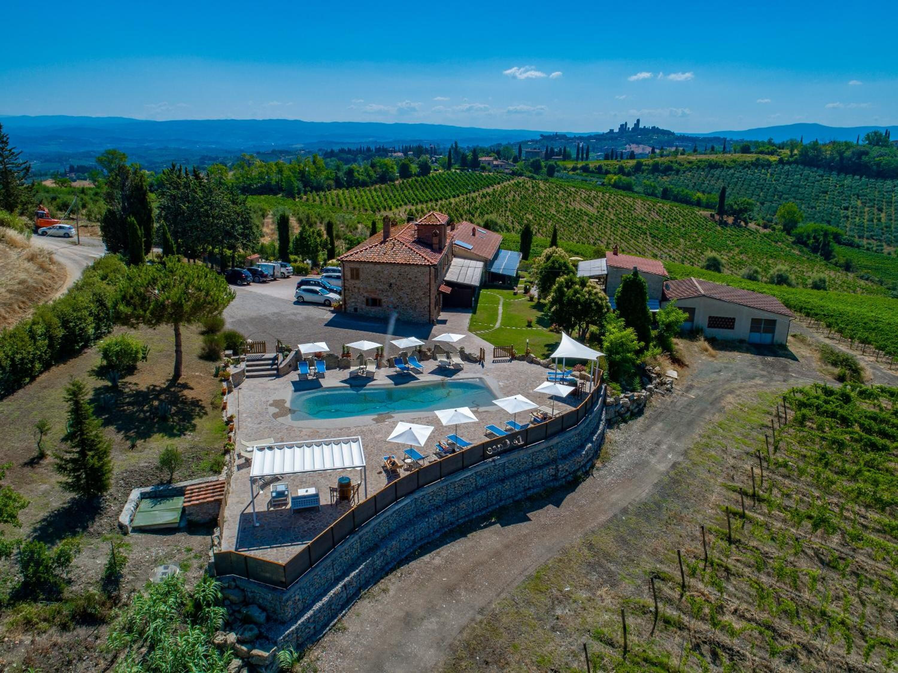 Una villa con piscina, mobiliario de exterior y vistas a viñedos.