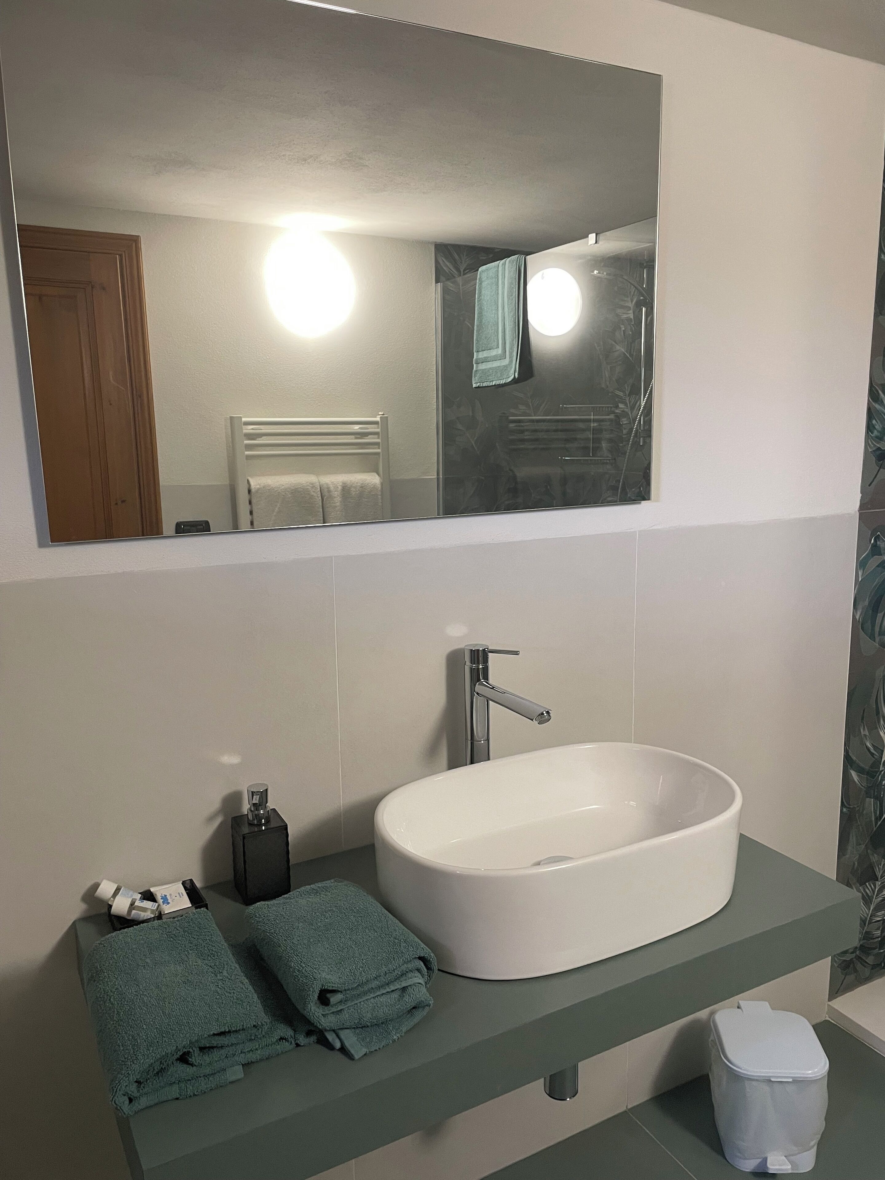 A bathroom with a white sink, a mirror, and a towel rack.