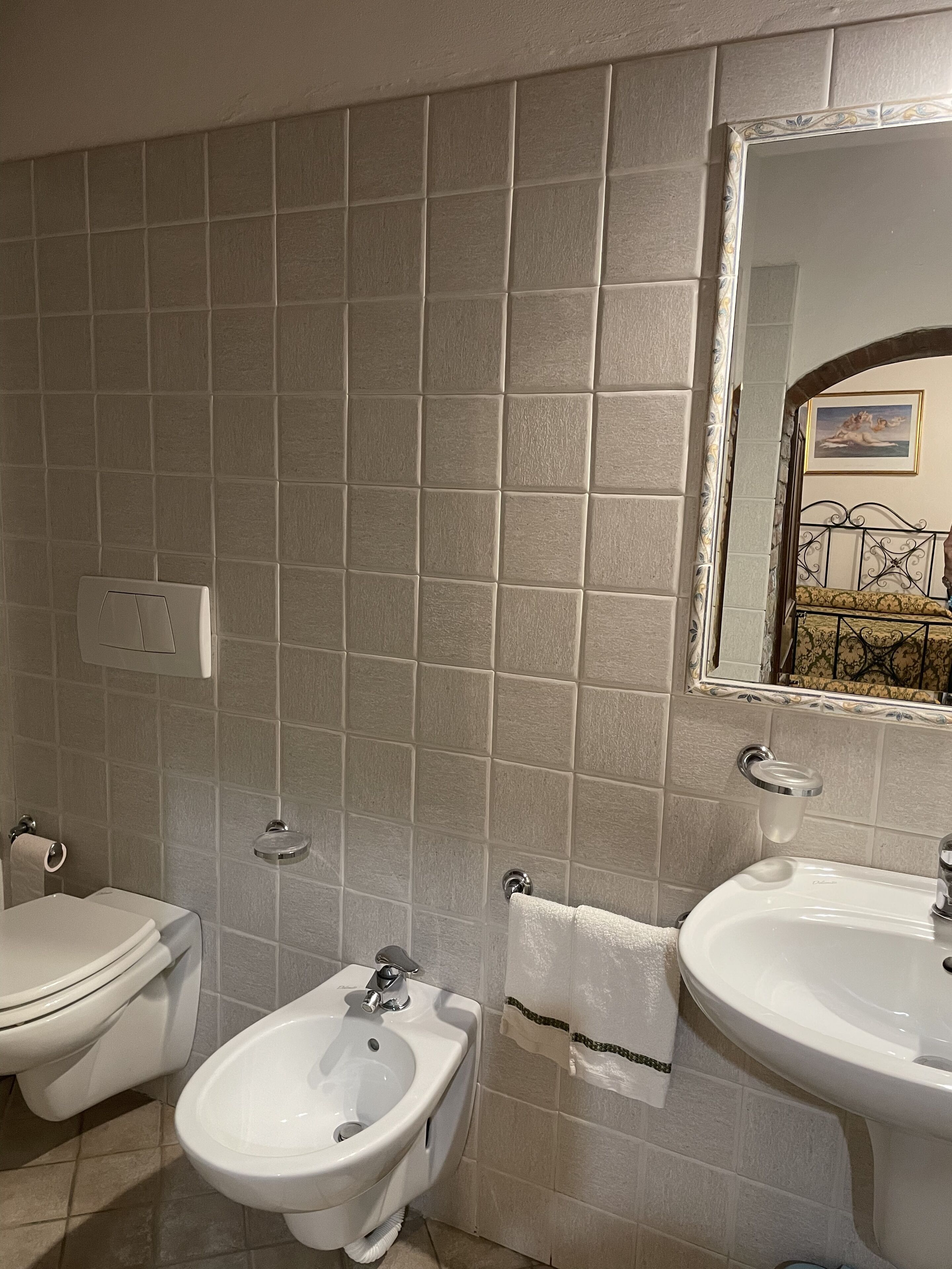 A bathroom with a bidet, toilet, and sink.