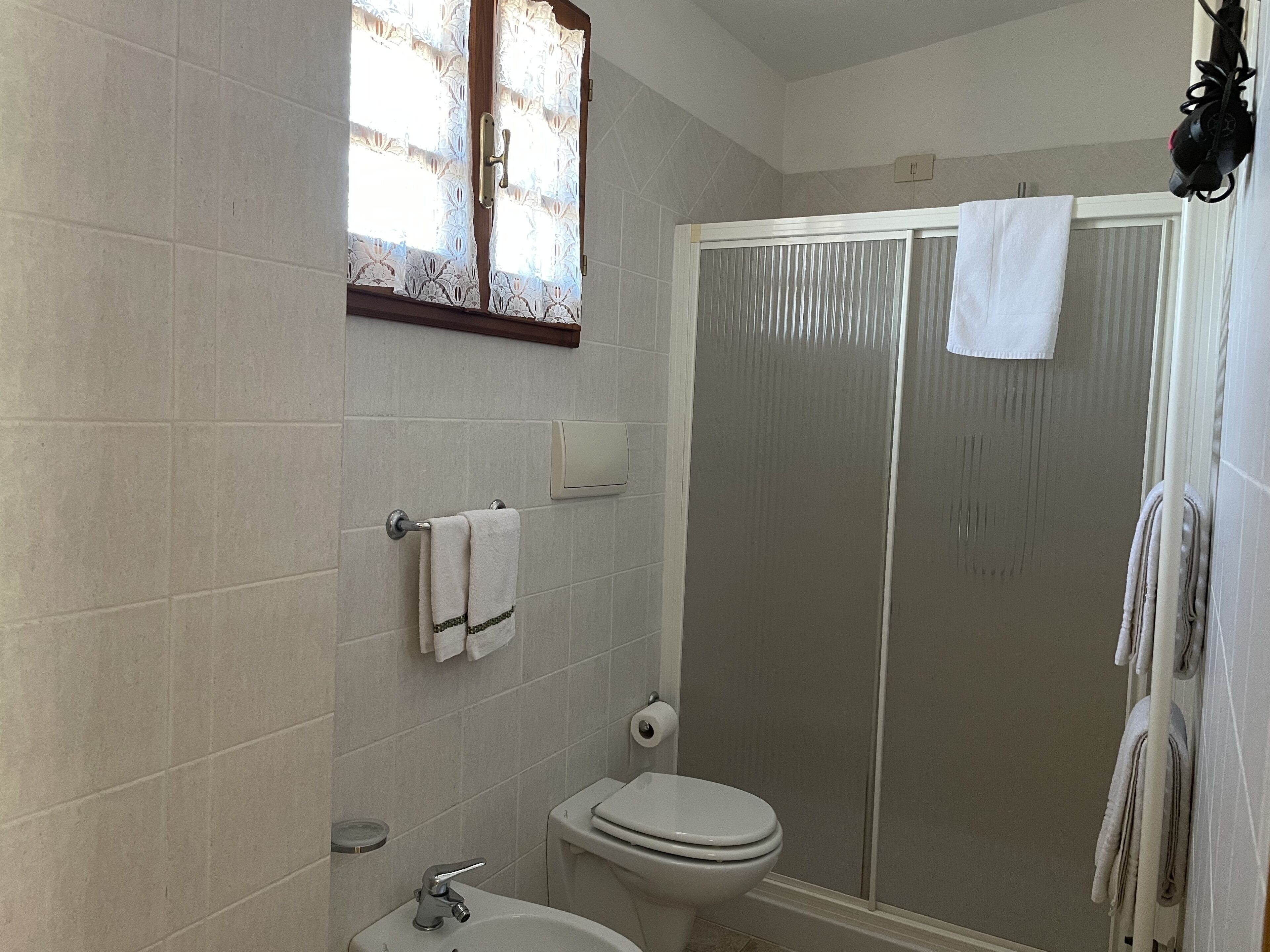 A bathroom with a toilet, sink, and shower.