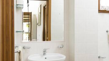 A bathroom with a white sink, a mirror, and a towel rack.