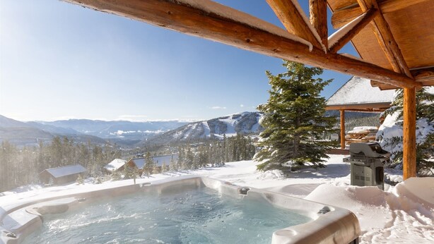 A hot tub with a snowy mountain view, wooden pergola, and a snow-covered tree. - Ski-in/ski-out "Alpine Escape" Cowboy Heaven Cabin-360 Degree Mtn View - Hot Tub (Big Sky)