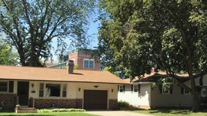 A two-story house with a garage, a brick facade, and a small front yard.